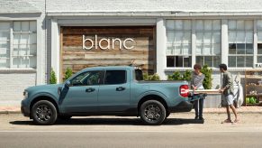 People putting wood in blue 2023 Ford Maverick, the only new 2023 pickup truck that costs less than $25,000