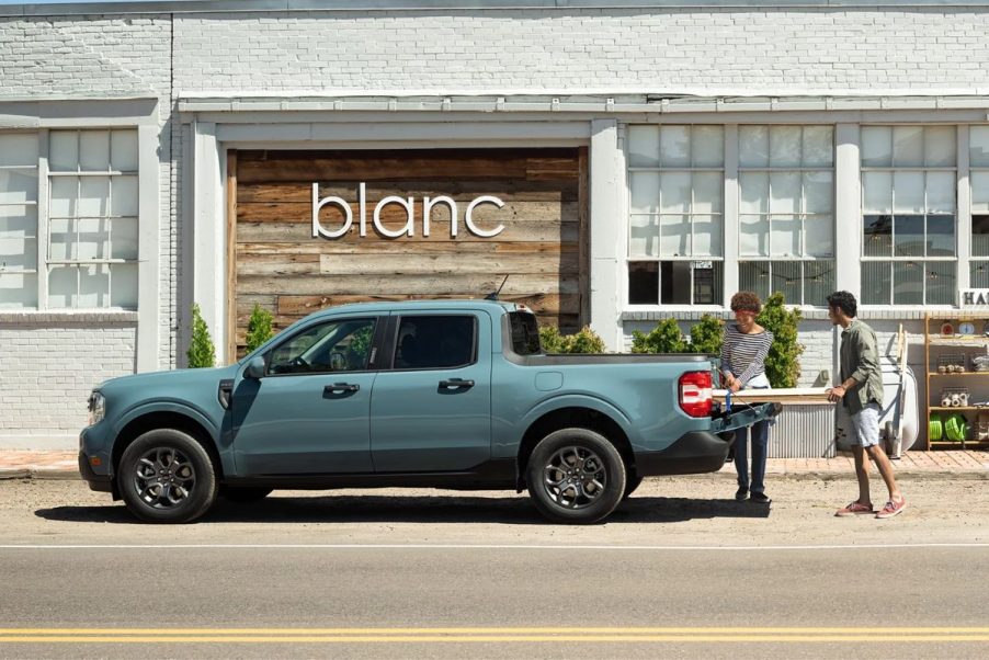 People putting wood in blue 2023 Ford Maverick, the only new 2023 pickup truck that costs less than $25,000