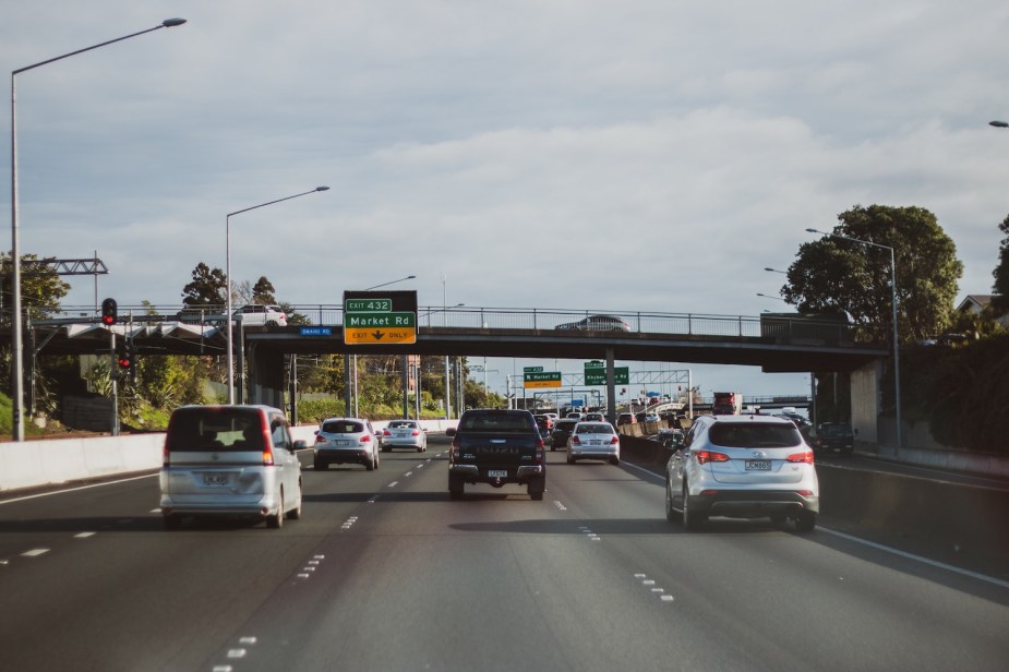 Traffic driving along a divided highway with some drivers following other cars.