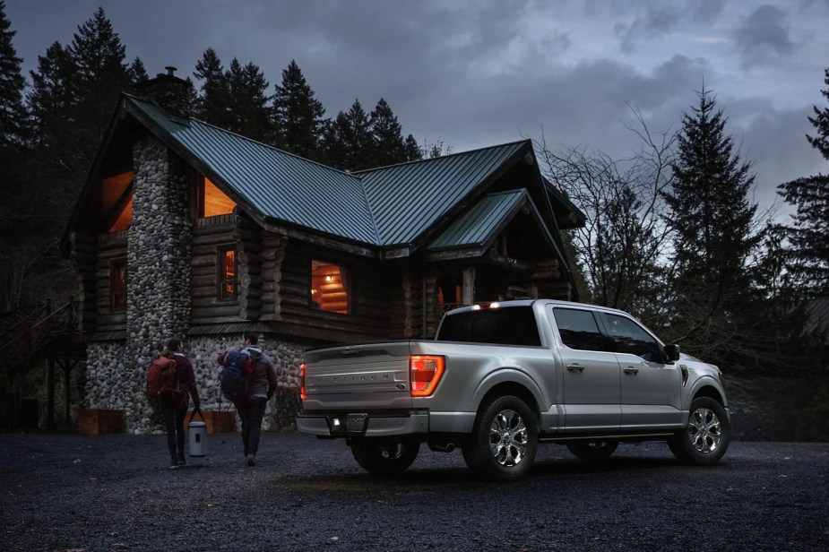 Silver 2023 Ford F-150 pickup truck, most popular car for wealthy people, parked near a cabin