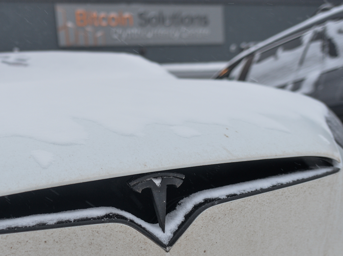 A white Tesla with Cold Weather Driving Range in an EV.