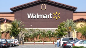 A walmart's storefront, palm trees visible in the foreground.