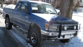 A Toyota T100 sits on a snowy road, it can be an off-road truck.