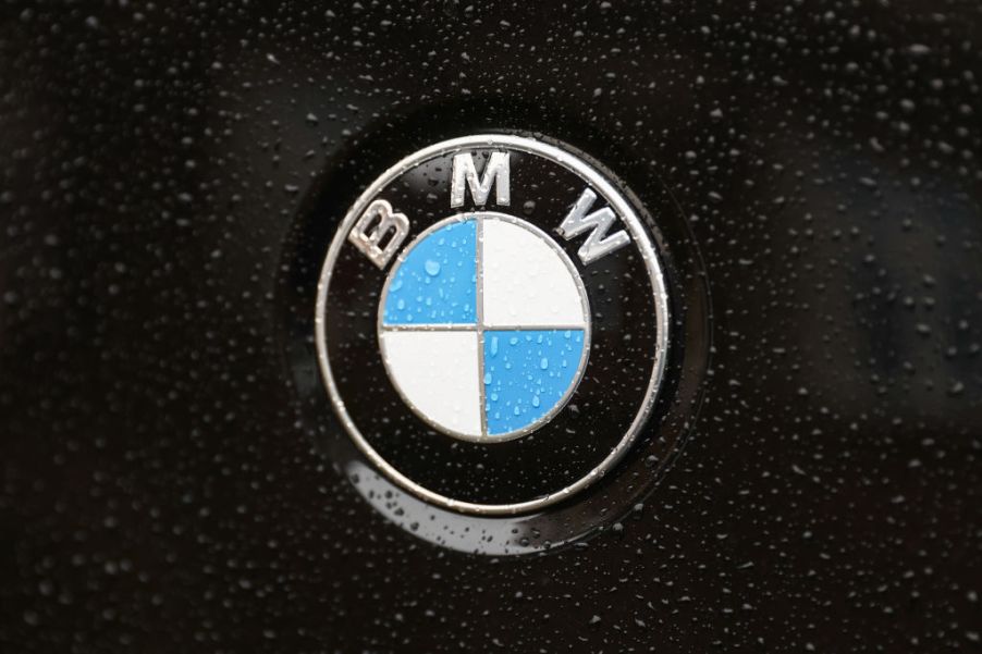 A BMW logo on a wet black car.