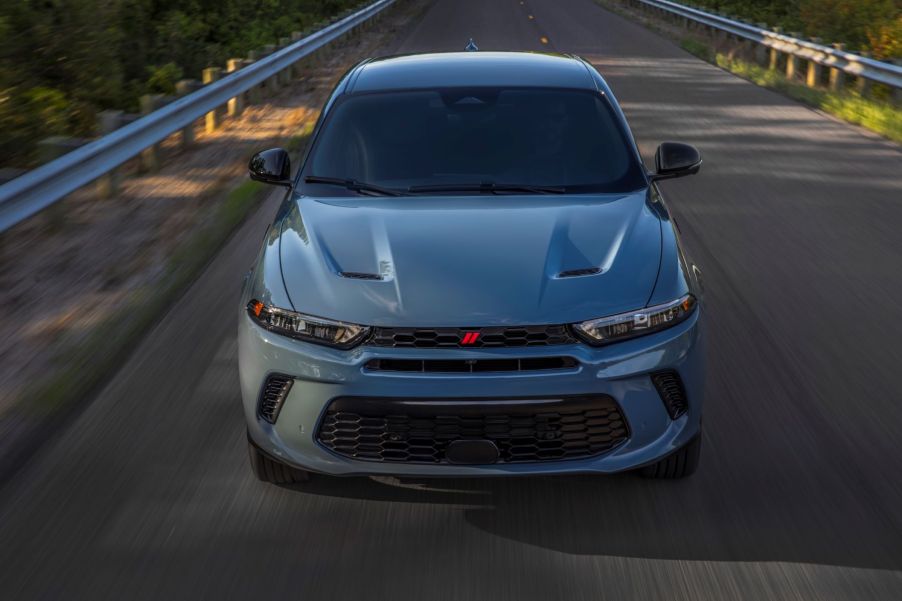 A blue-gray 2023 Dodge Hornet plug-in hybrid electric vehicle (PHEV) driving down a highway