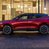 A side profile shot of a red 2023 Chevrolet Blazer RS midsize SUV parked on a cobblestone crosswalk