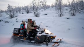 A family riding on a snowmible.