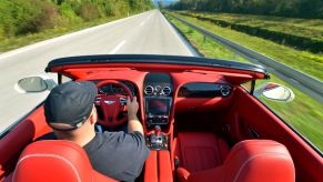 A man steering a 2012 Bentley Continental GT Convertible in Rovinj, Croatia