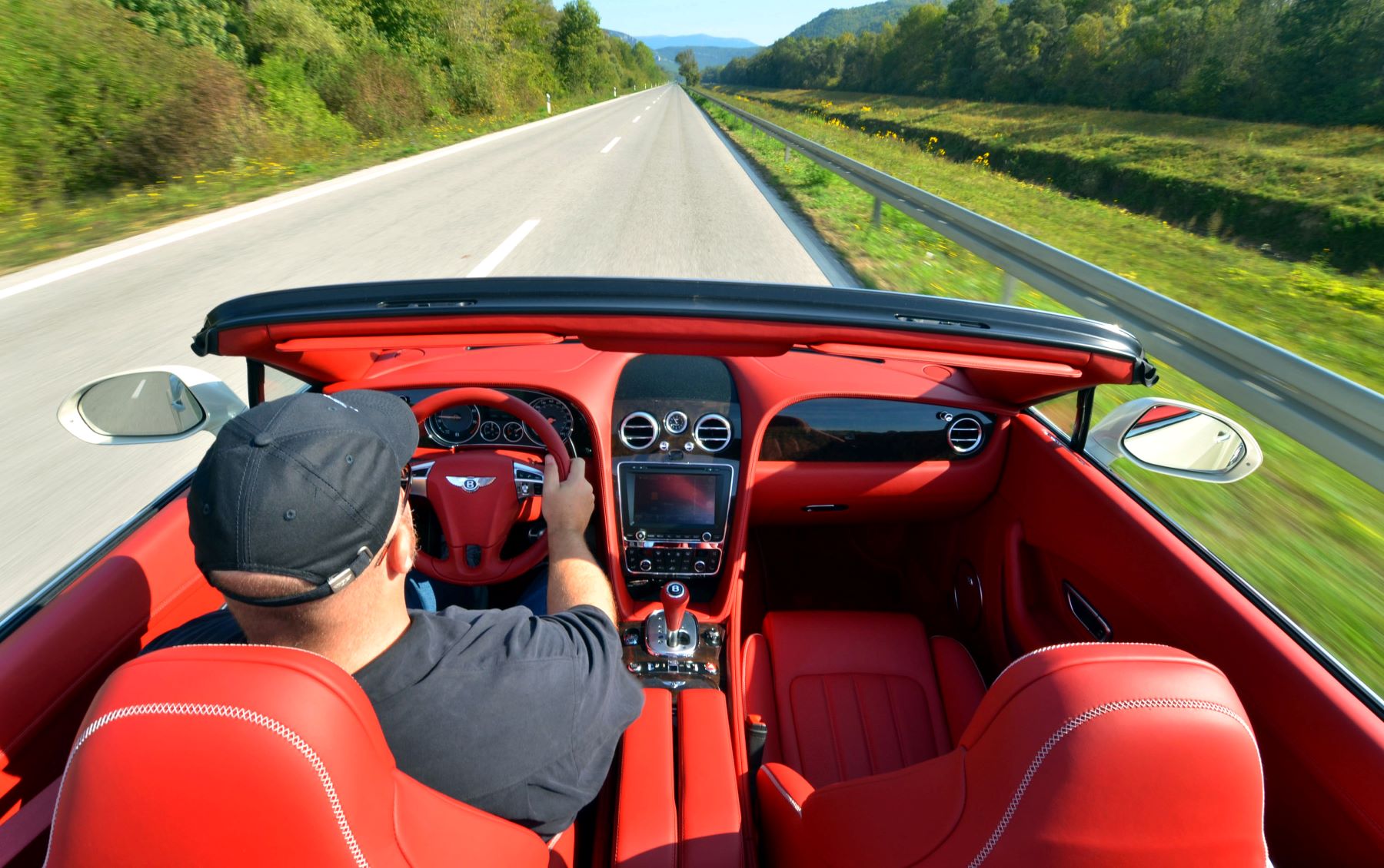 A man steering a 2012 Bentley Continental GT Convertible in Rovinj, Croatia