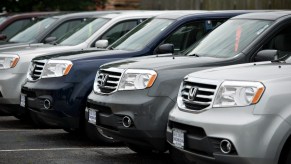 A group of 2015 Honda Pilot three-row SUVs sits on display.