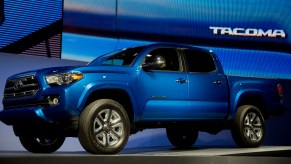 A blue 2016 Toyota Tacoma midsize pickup truck is on display.