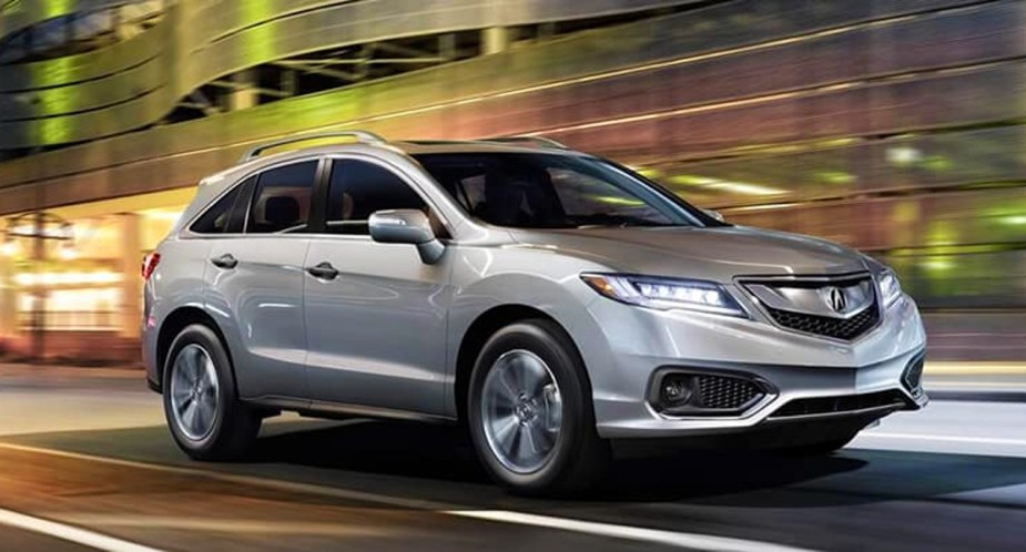 A gray 2018 Acura RDX small luxury SUV is driving on the road. 