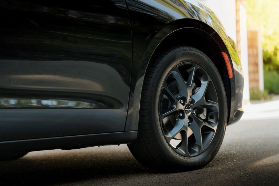 Close photo of a car wheel, parked on asphalt