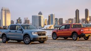 A blue 2022 Ford Maverick Hybrid XLT and red Ford Maverick 2L-EcoBoost AWD Lariat compact pickup truck models