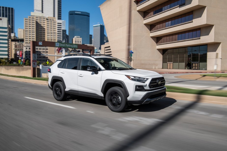 A white 2022 Toyota RAV4 which shows the advantages the 2022 Toyota RAV4 as it drives down the road. 