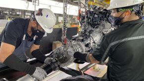 Two San Antonio factory workers assemble the hybrid Toyota Tundra pickup truck's 10-speed automatic transmission.