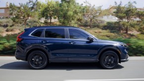 A blue 2023 Honda CR-V driving down the road.