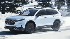 A white 2023 Honda HR-V is driving in snow.