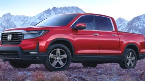 A red 2023 Honda Ridgeline midsize pickup truck is parked.