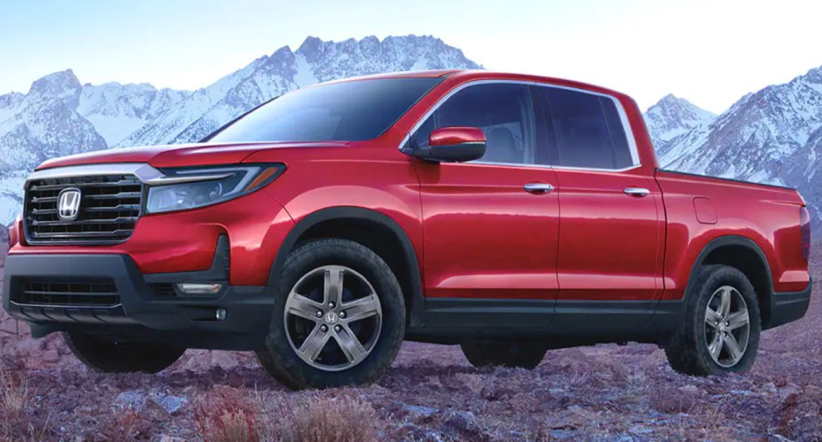 A red 2023 Honda Ridgeline midsize pickup truck is parked.