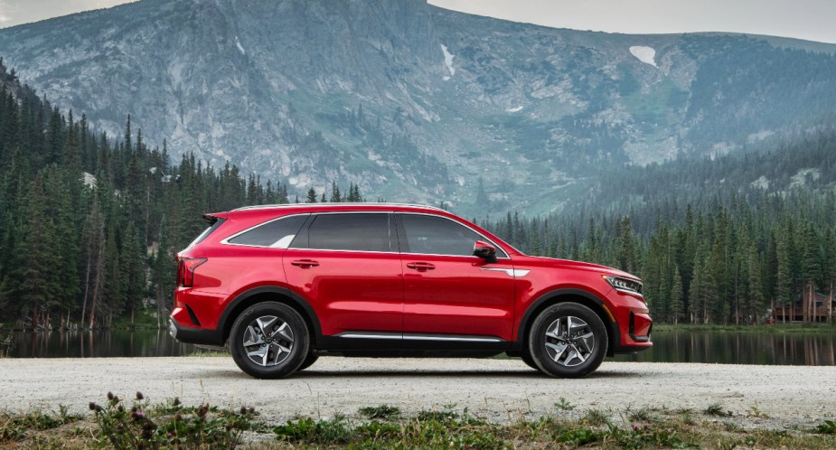 A red 2023 Kia Sorento Hybrid midsize SUV is parked outdoors. 