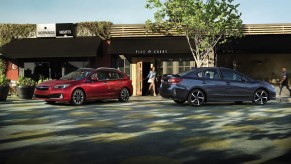 A 2023 Subaru Impreza hatchback and sedan parked in front of a store