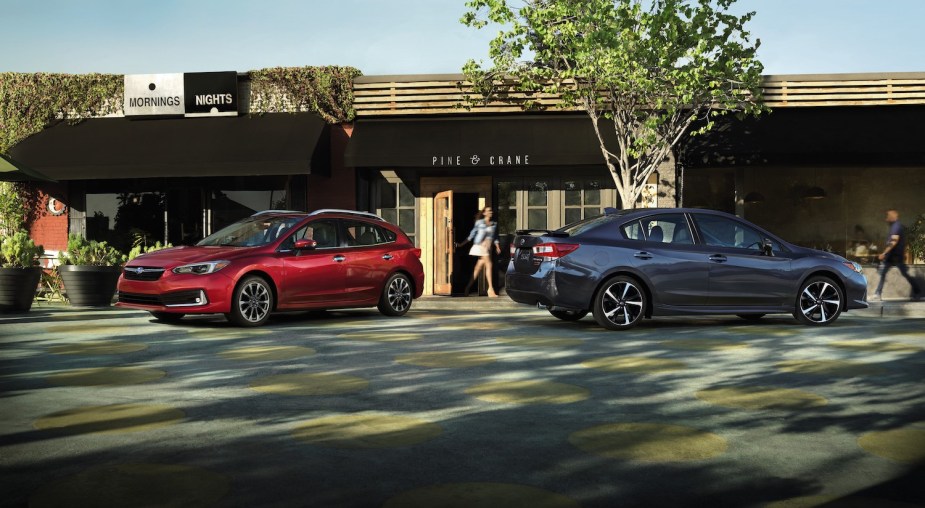 A 2023 Subaru Impreza hatchback and sedan parked in front of a store