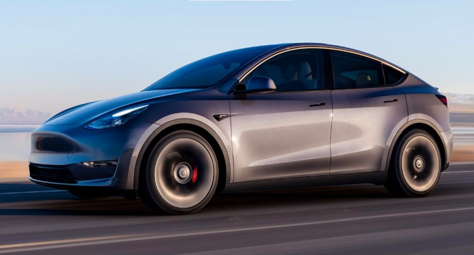 A gray 2023 Tesla Model Y is driving on the road.