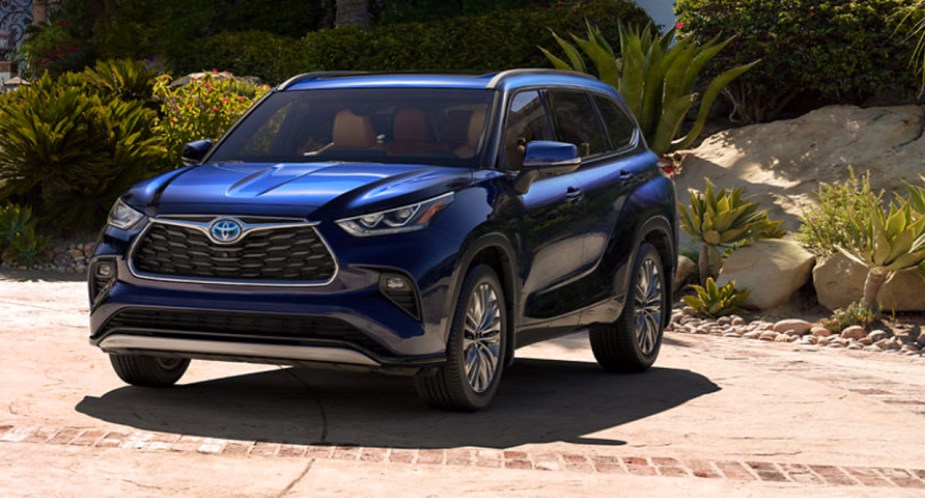 A blue 2023 Toyota Highlander Hybrid midsize SUV is parked. 