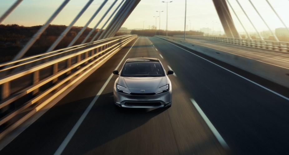 A gray 2023 Toyota Prius is driving on the road. 