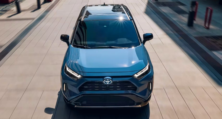 A blue 2023 Toyota RAV4 Hybrid small hybrid SUV is driving. 