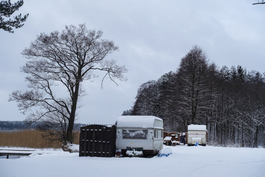 An RV parked in the snow that could use an electric heater in the RV. 