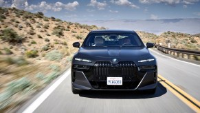 A black BMW i7 driving down the road.