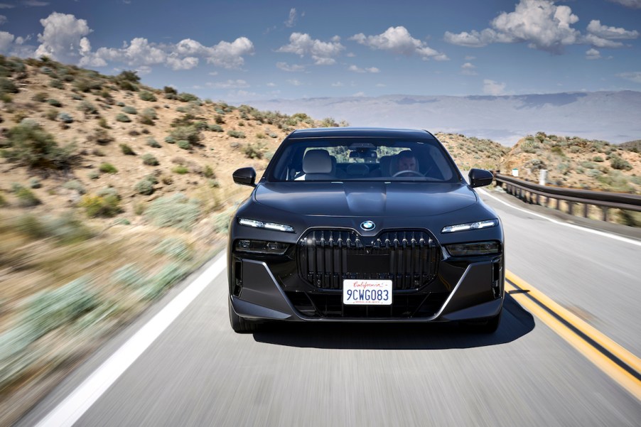 A black BMW i7 driving down the road.