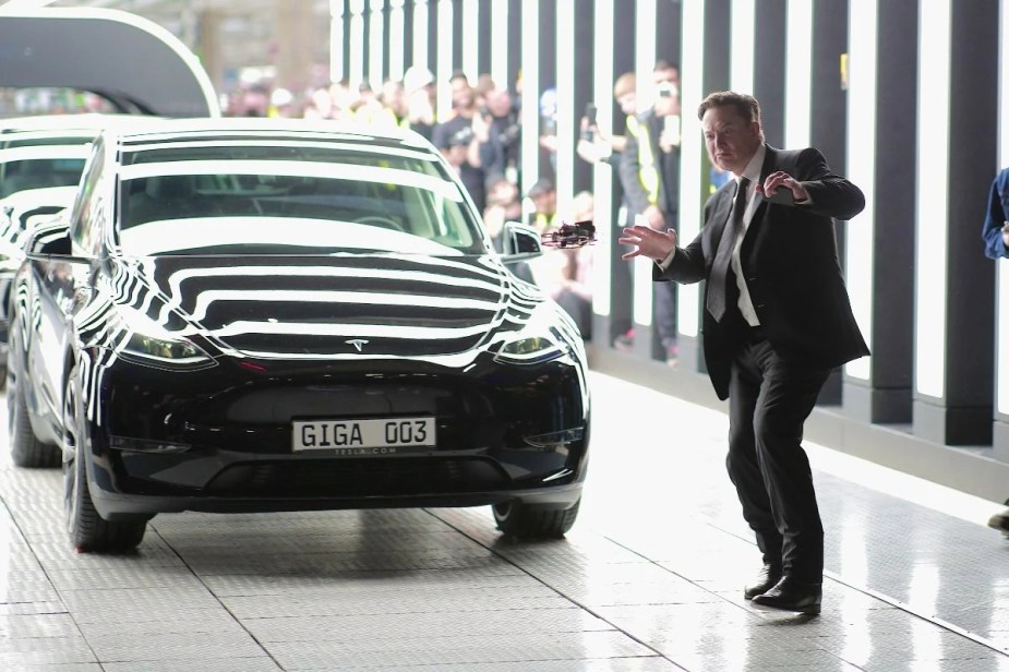 Elon Musk dancing by Tesla Model Y, showing how customers cancel orders due to his Twitter drama