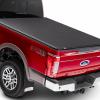 A red ford truck with a tonneau cover on the cargo bed. There are a few reasons to buy one.