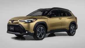 Front angle view of gold 2023 Toyota Corolla Cross Hybrid crossover SUV