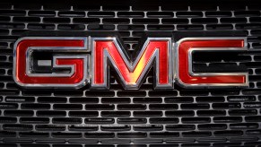 Closeup of a classic General Motors Company GMC logo on the grille of a truck at an auto show.