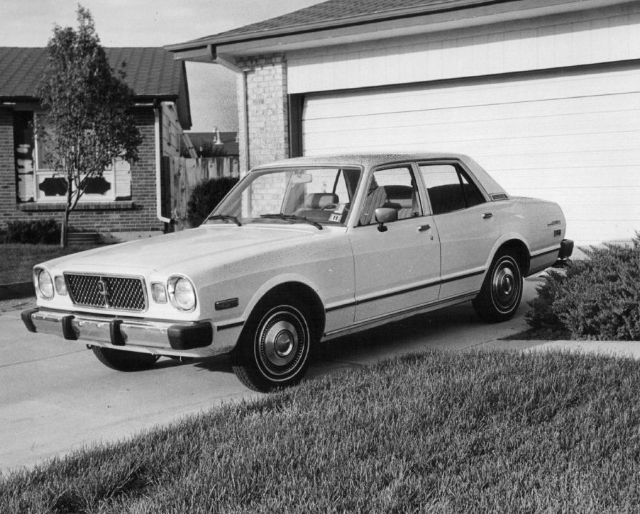 A Toyota Cressida parked in a driveway in a black and white picture.