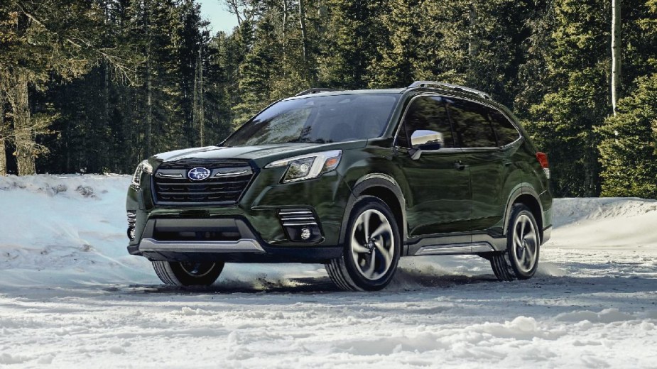 Green 2023 Subaru Forester crossover SUV parked on a snowy road, there are many reasons to buy the Premium trim.