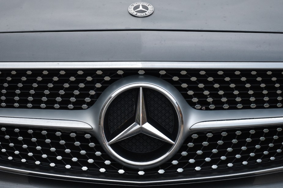 A Mercedes-Benz logo on the front of a car. 