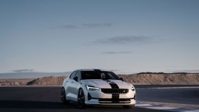 A white Polestar 2 BST Edition 270 electric muscle car model with a racing stripe on a race track