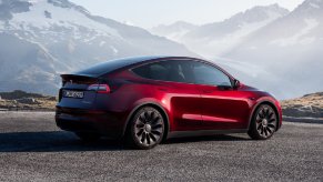 Rear angle view of new red 2023 Tesla Model Y electric crossover SUV, highlighting how much fully loaded version costs