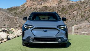 A light blue 2022 Subaru Solterra compact electric SUV model with an aesthetic fake grille panel