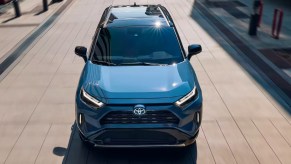 A blue 2023 Toyota RAV4 Hybrid small hybrid SUV is driving.