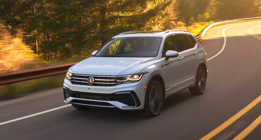 A white 2023 Volkswagen Tiguan small SUV is driving on the road.