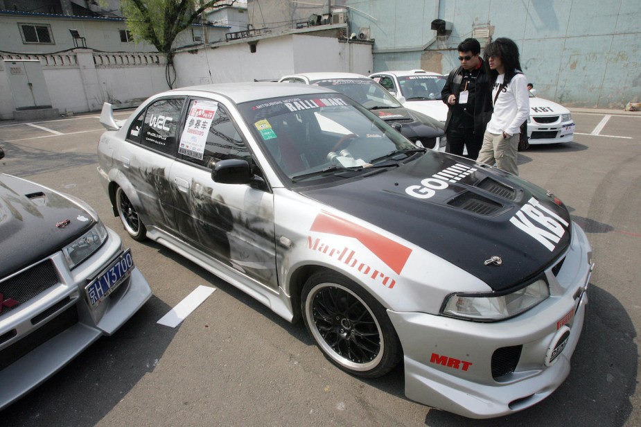 Visitors admire the souped-up vehicles at a modified cars.