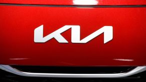 The new Kia logo on a red vehicle hood seen at the Automobile Barcelona International Motor Show