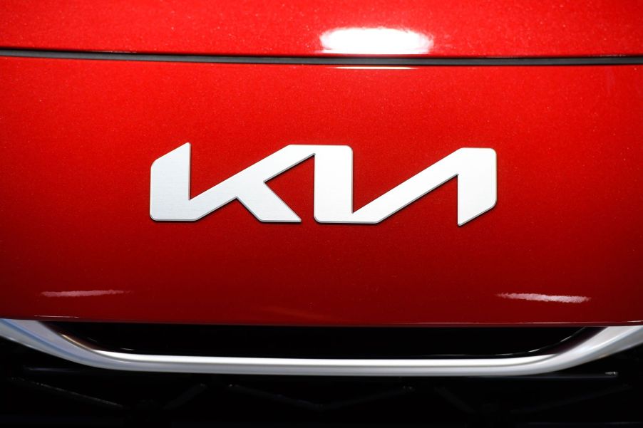 The new Kia logo on a red vehicle hood seen at the Automobile Barcelona International Motor Show