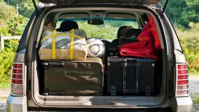 The rear cargo space of an SUV is shown packed full with items